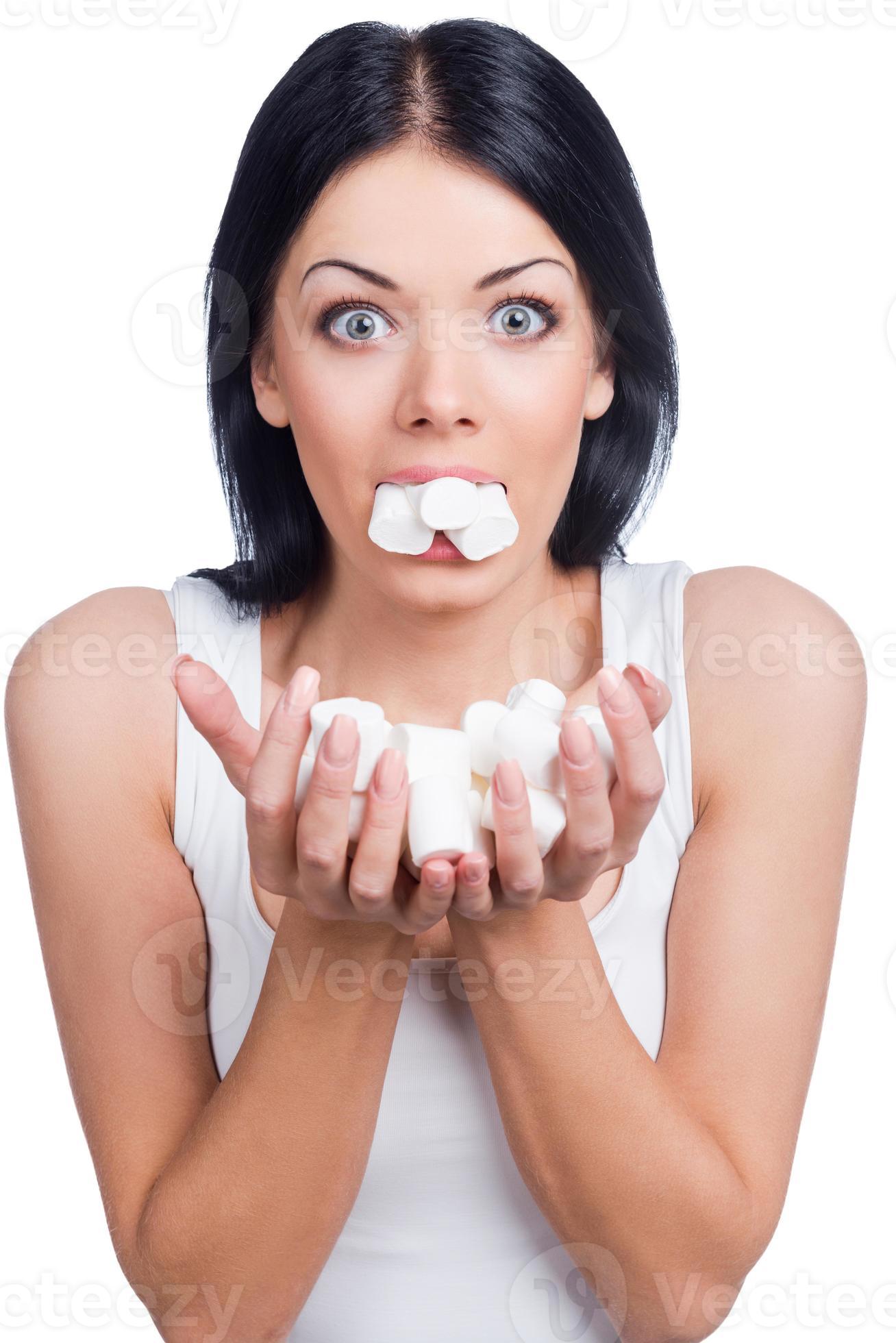 Candy life. Beautiful women holding marshmallow in her mouth and hands