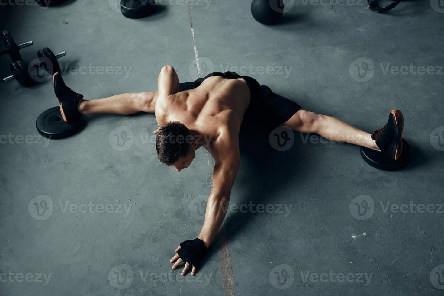 Top view of fit young man doing the splits while exercising in gym photo