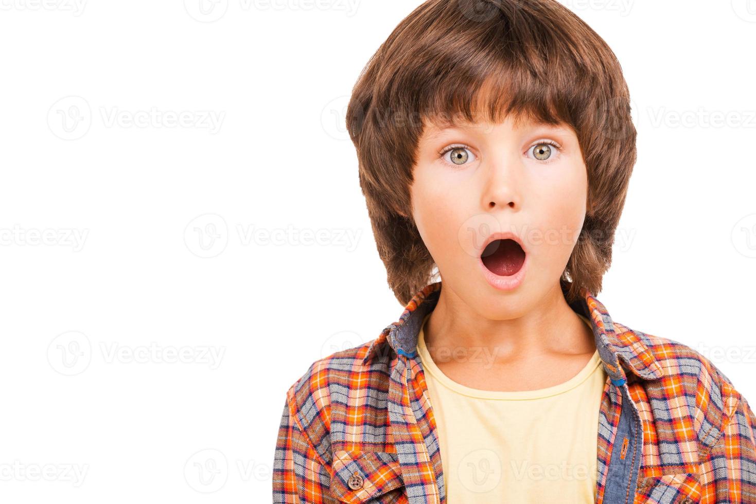 What a surprise Shocked little boy keeping mouth open while standing isolated on white photo