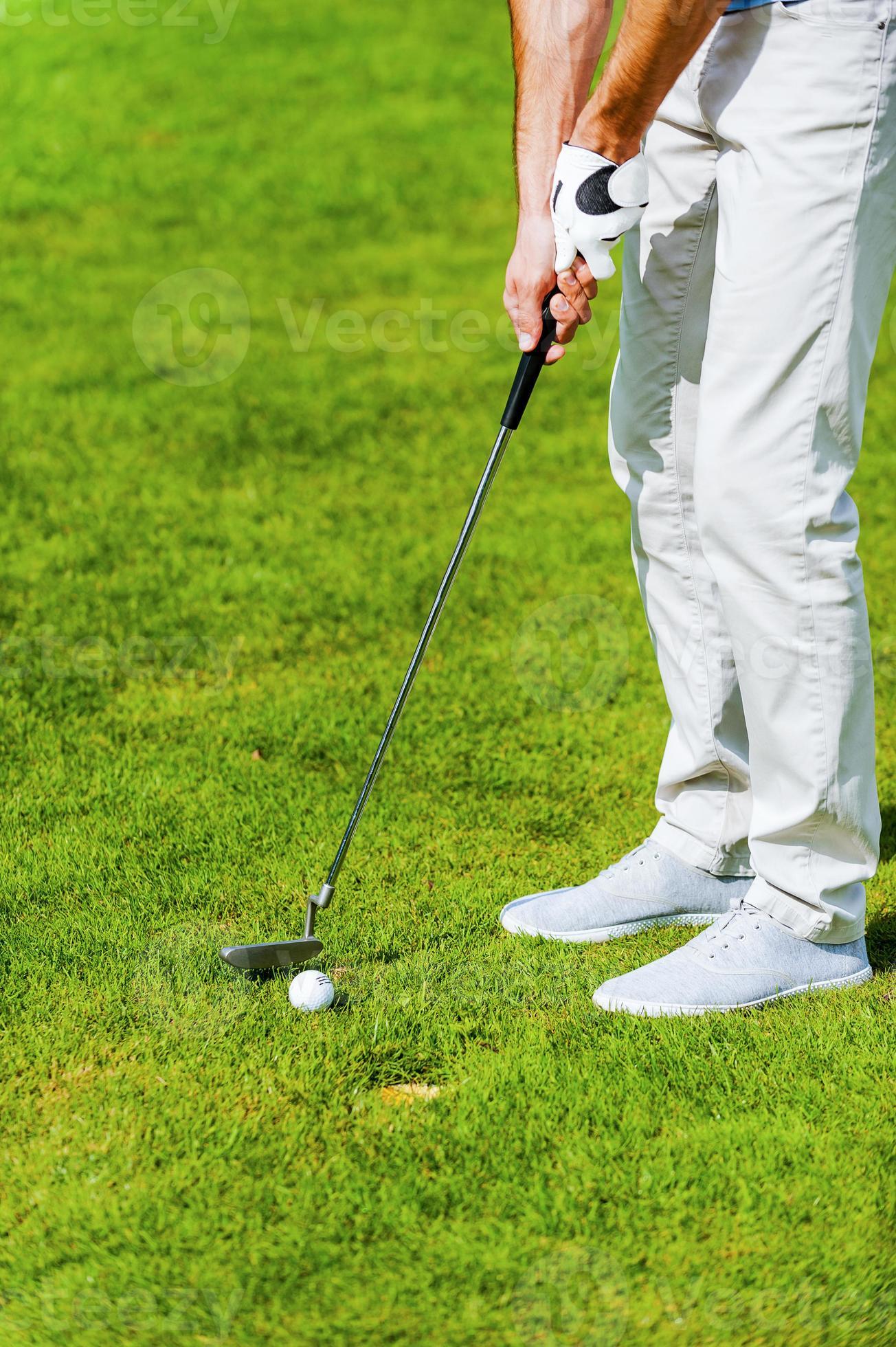 One shot to success. Close-up of man playing golf while standing on green  and near the hole 13288796 Stock Photo at Vecteezy