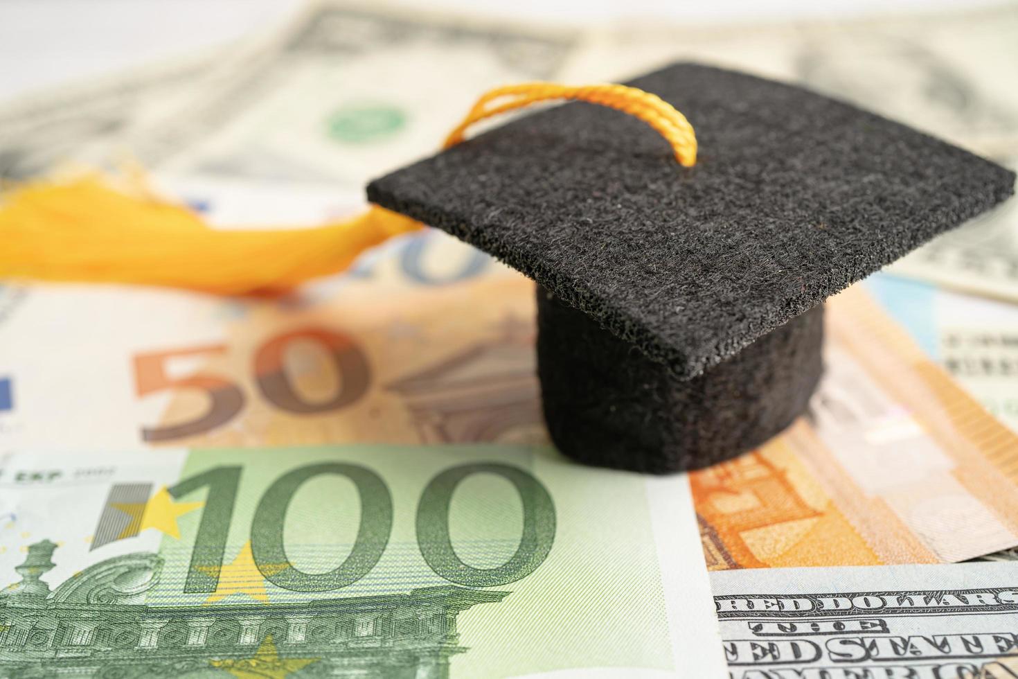 sombrero de la brecha de graduación en el dinero de los billetes en dólares estadounidenses, concepto de enseñanza de aprendizaje de la tarifa de estudio de educación. foto