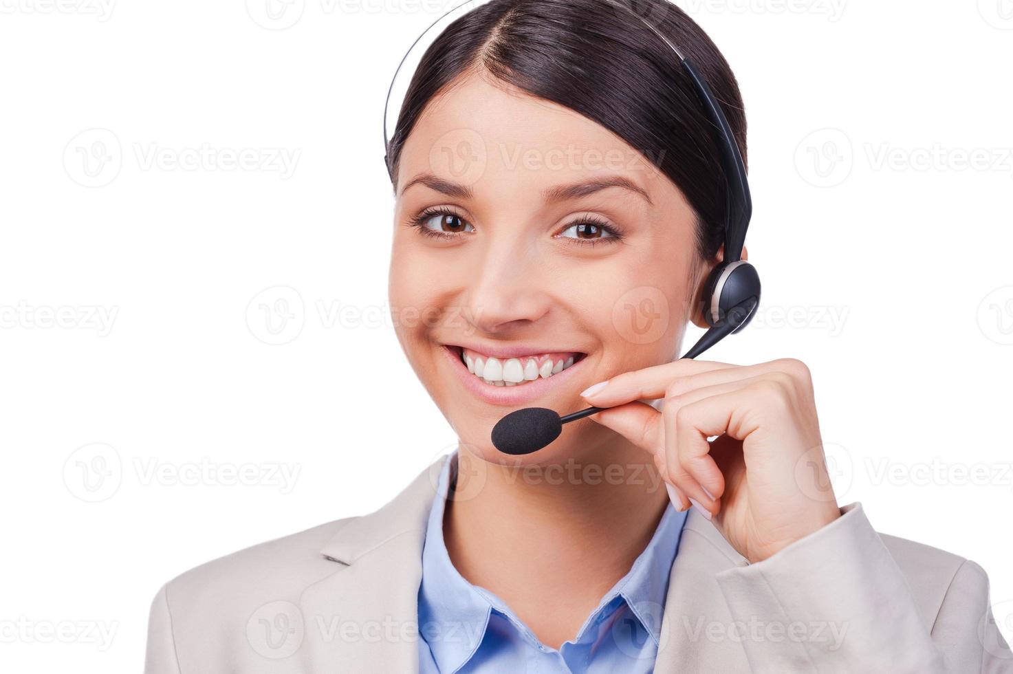 Busy at her work. Confident young customer service smiling while standing against white background photo