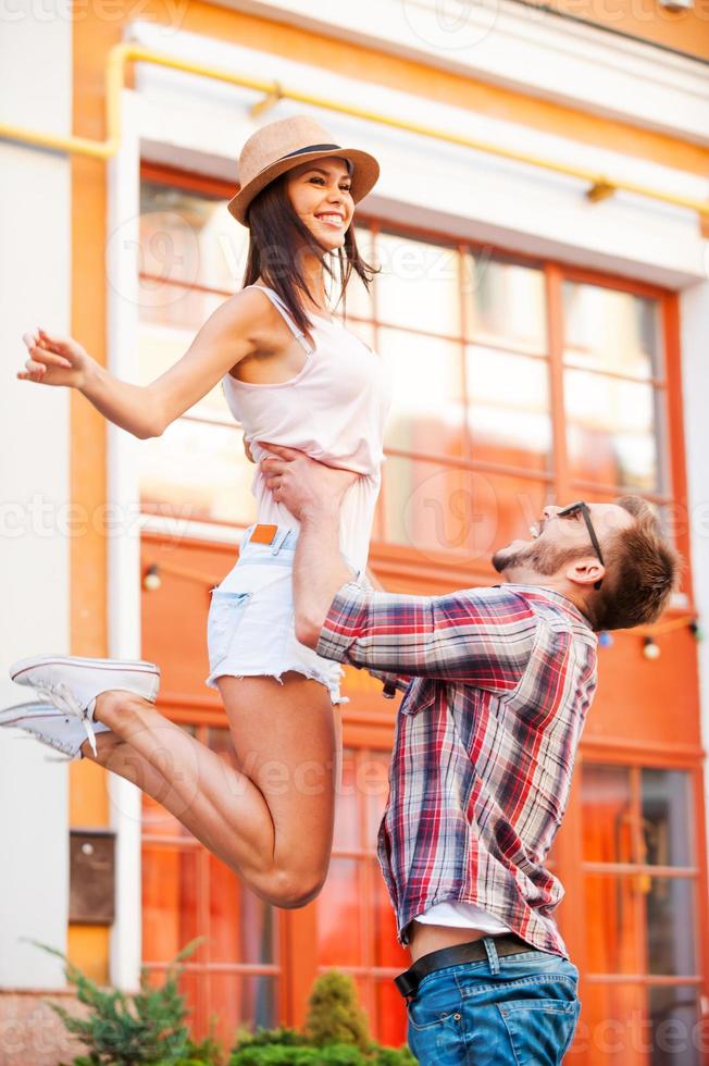 Having fun together. Happy young loving couple having fun while standing outdoors photo