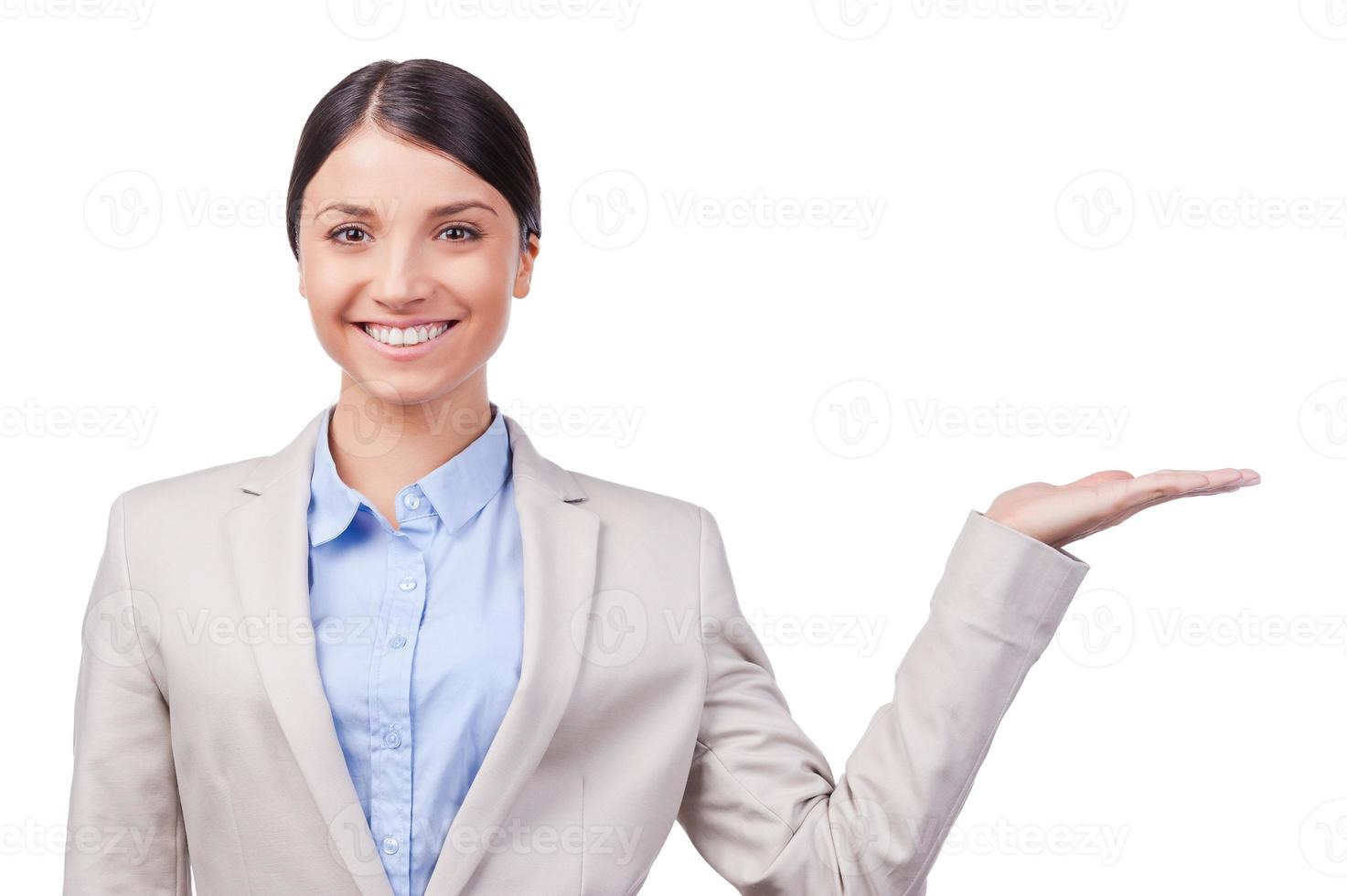 su anuncio en su mano. sonriente joven empresaria sosteniendo espacio de copia mientras está de pie contra el fondo blanco foto