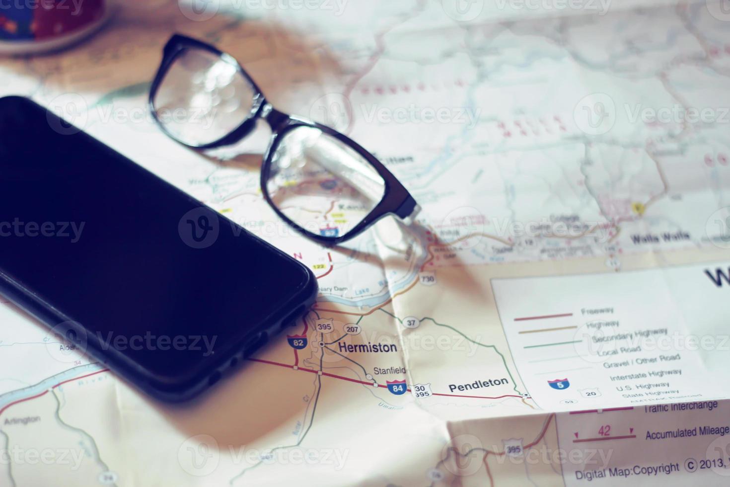 Map, map of Washington state, pen, glasses, cell phone, coffee cup on the table. photo