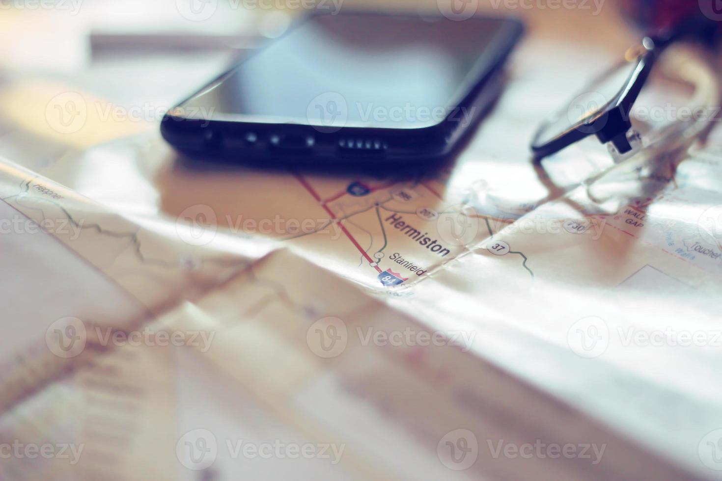 Map, map of Washington state, pen, glasses, cell phone, coffee cup on the table. photo