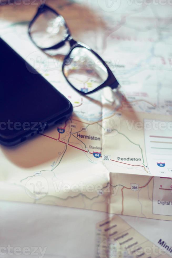 Map, map of Washington state, pen, glasses, cell phone, coffee cup on the table. photo