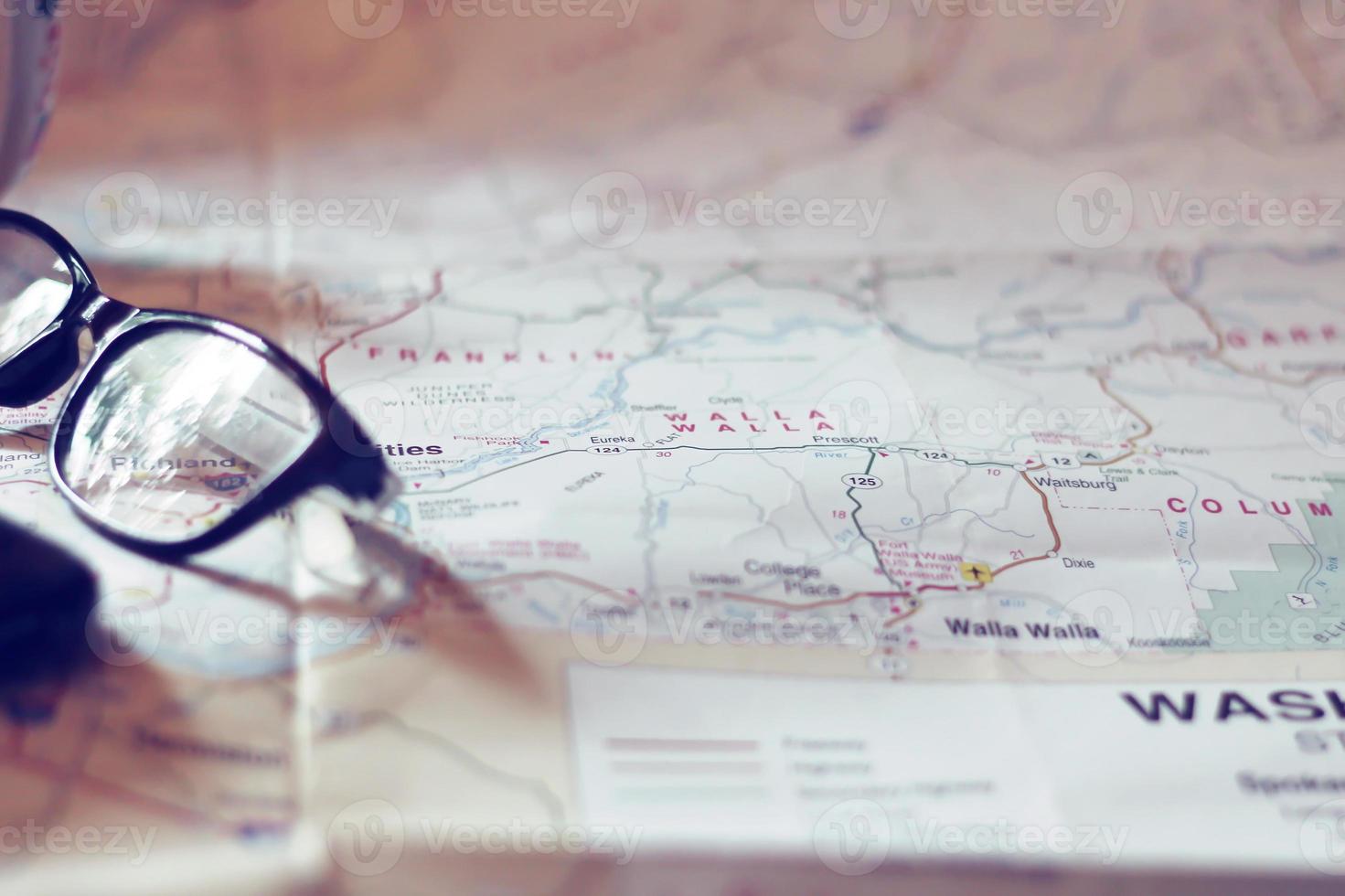 Map, map of Washington state, pen, glasses, cell phone, coffee cup on the table. photo