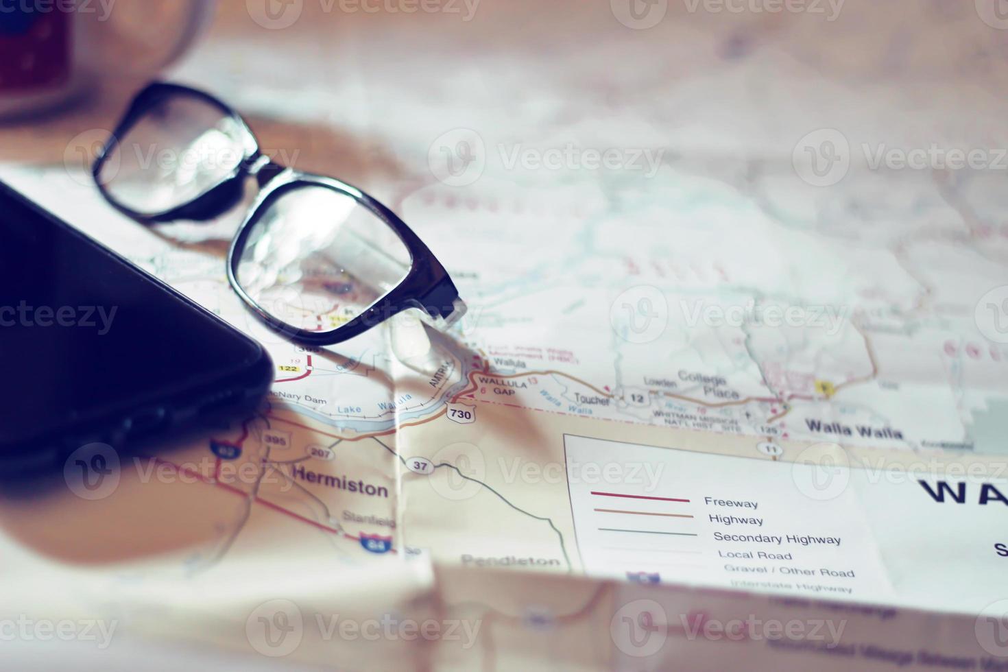 Map, map of Washington state, pen, glasses, cell phone, coffee cup on the table. photo