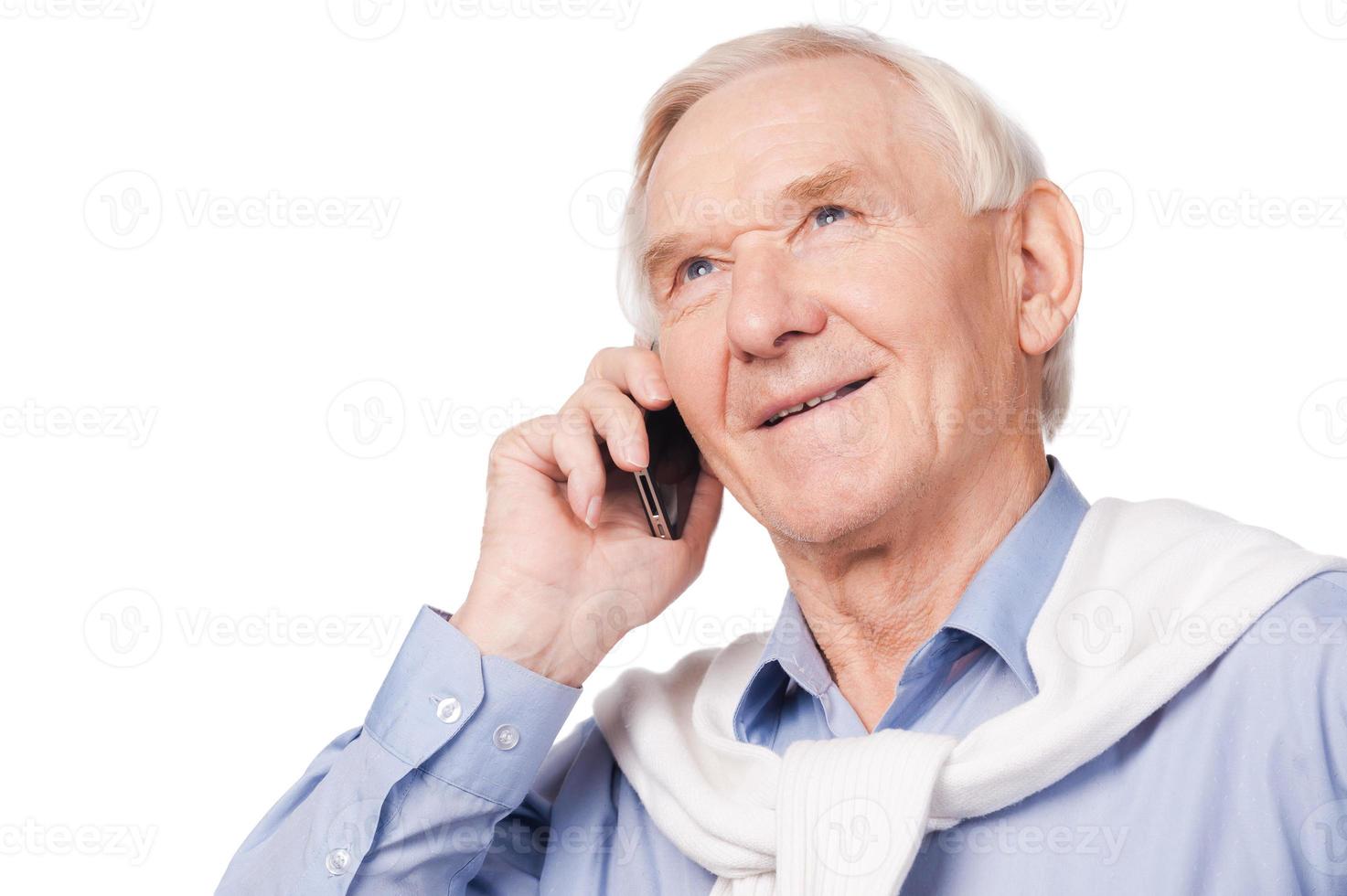 Up with times. Portrait of happy senior man smiling at camera while standing against white background photo