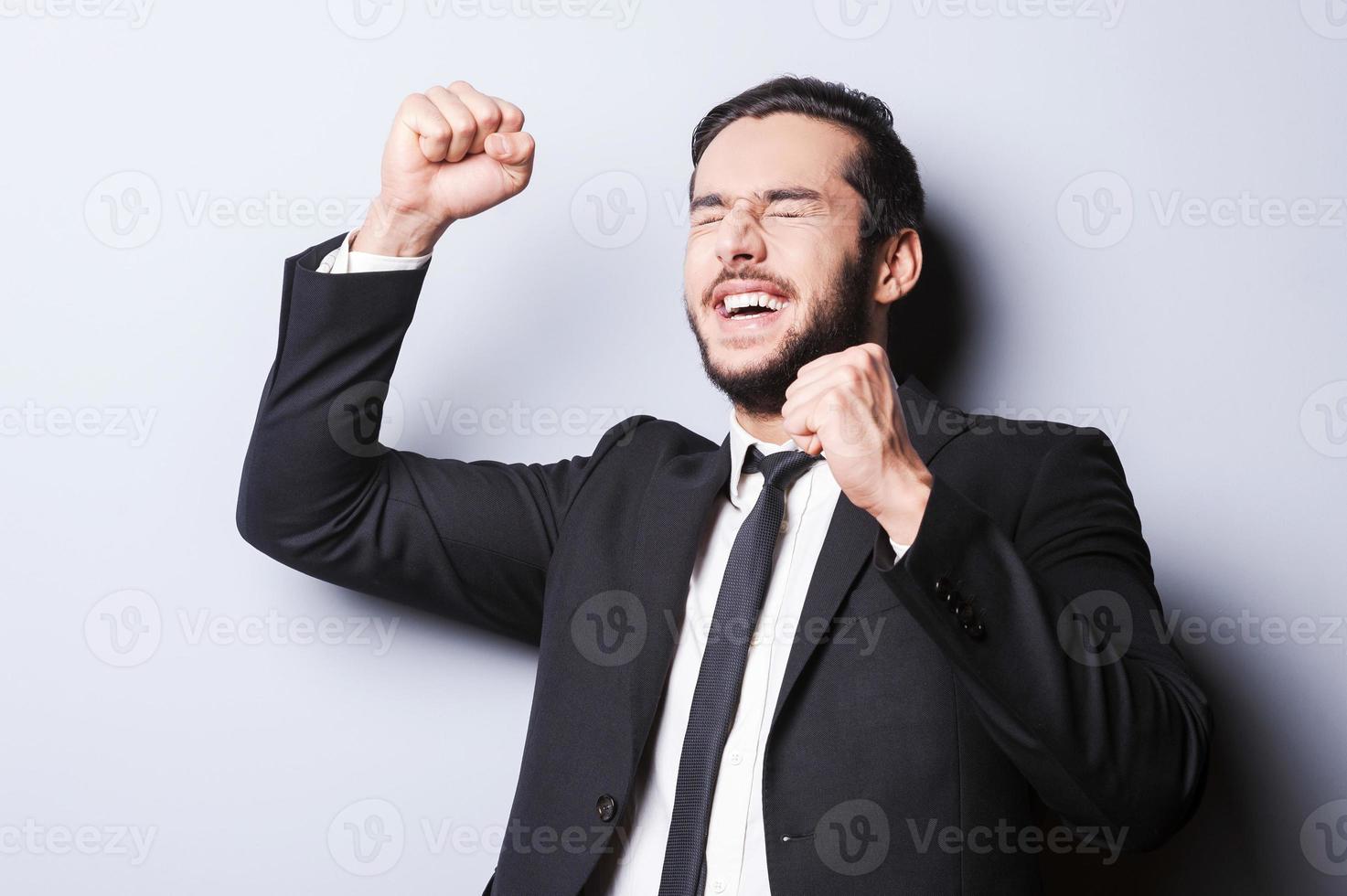 Successful businessman. Happy mature man in formalwear gesturing and keeping eyes closed while standing against grey background photo