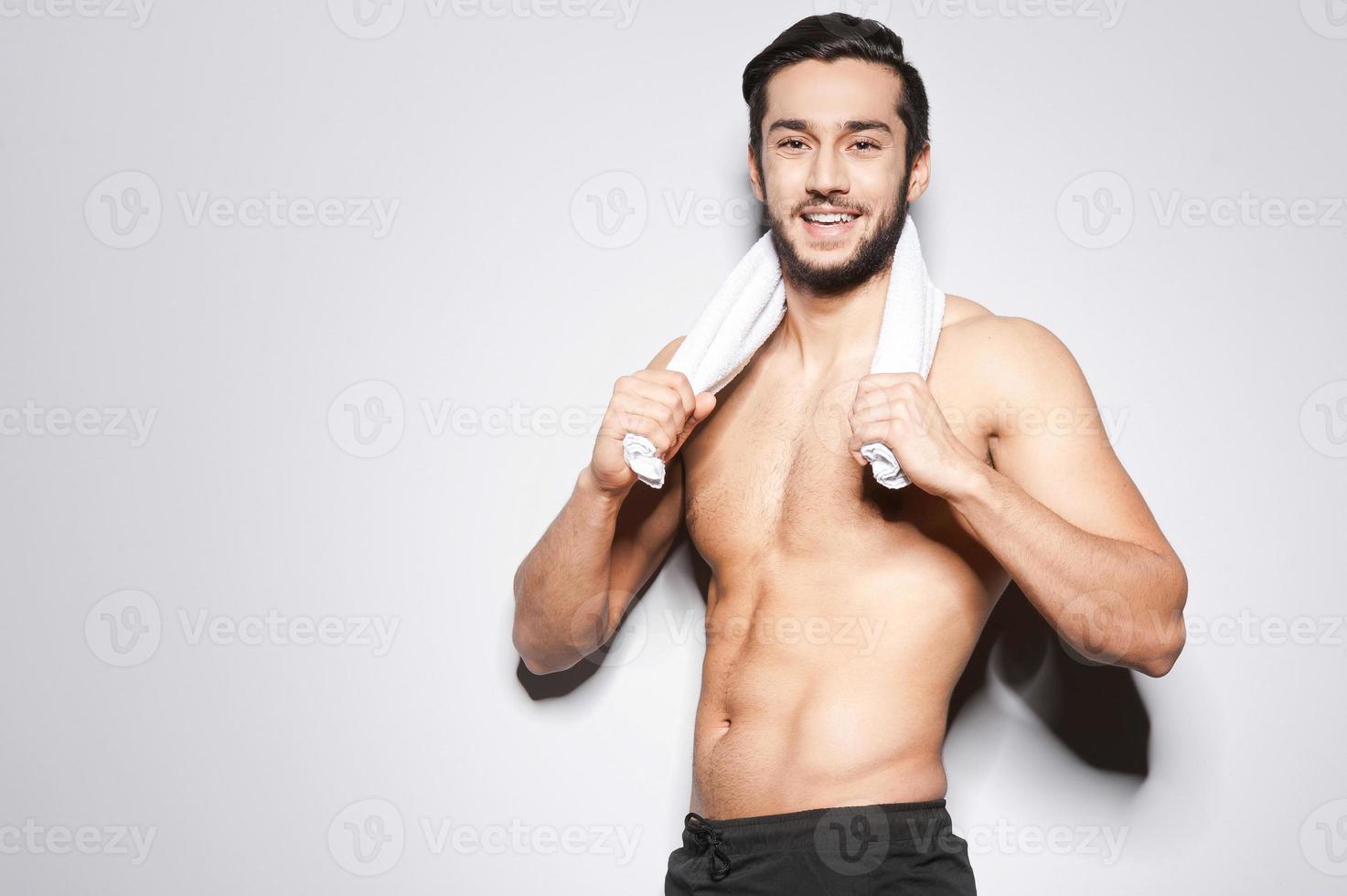 hombre después del entrenamiento. apuesto joven musculoso con toalla en los  hombros mirando a la cámara y sonriendo 13556247 Foto de stock en Vecteezy