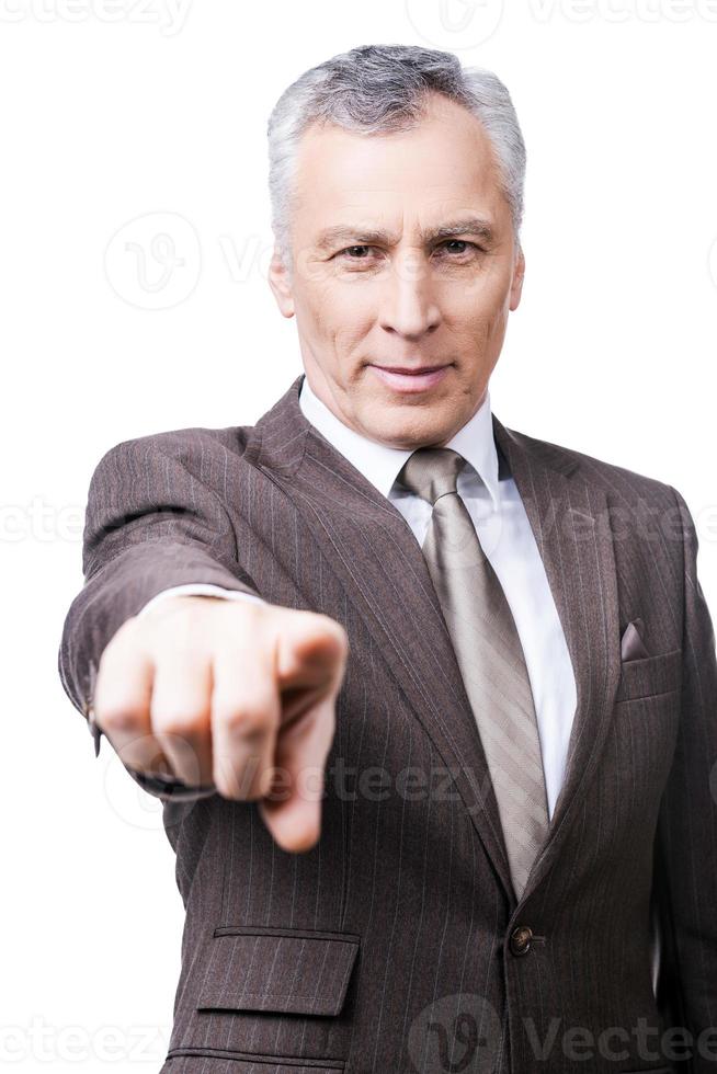 You are the next Confident mature man in formalwear pointing you while standing against white background photo