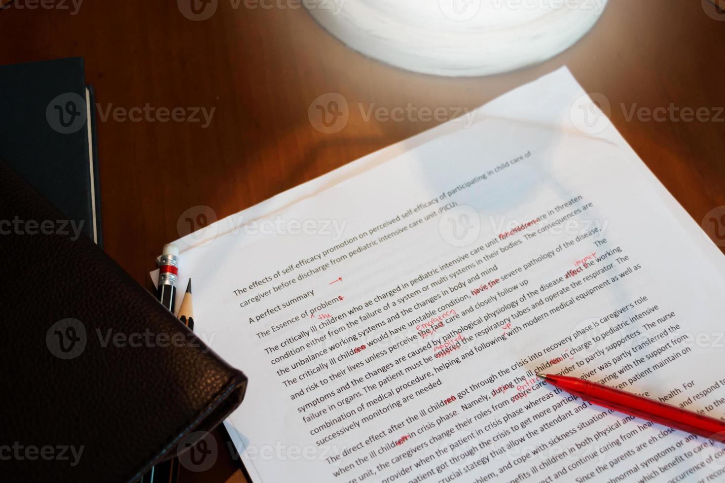 proofreading paper on wooden desk photo