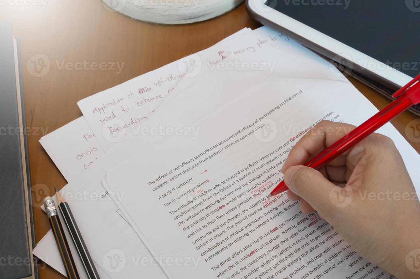 proofreading paper on wooden desk photo