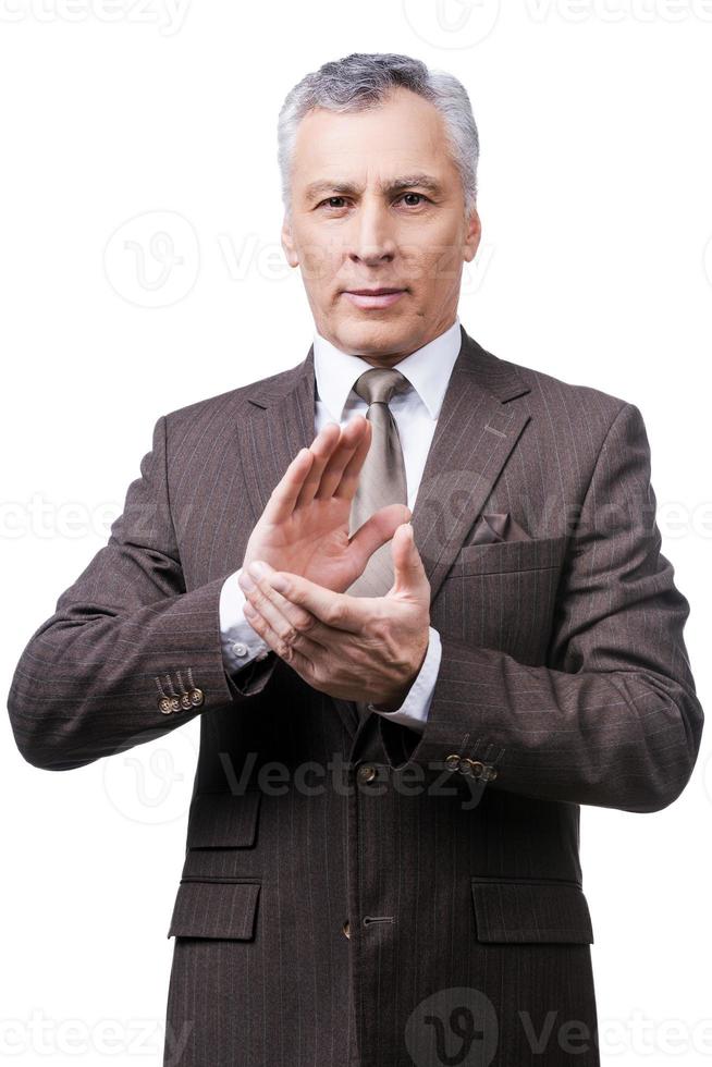 Celebrating success. Confident mature man in formalwear clapping hands and smiling while standing against white background photo