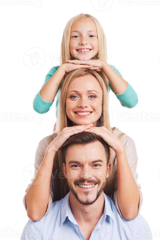 somos familia familia feliz de tres apoyándonos el uno al otro y sonriendo mientras estamos de pie contra el fondo blanco foto