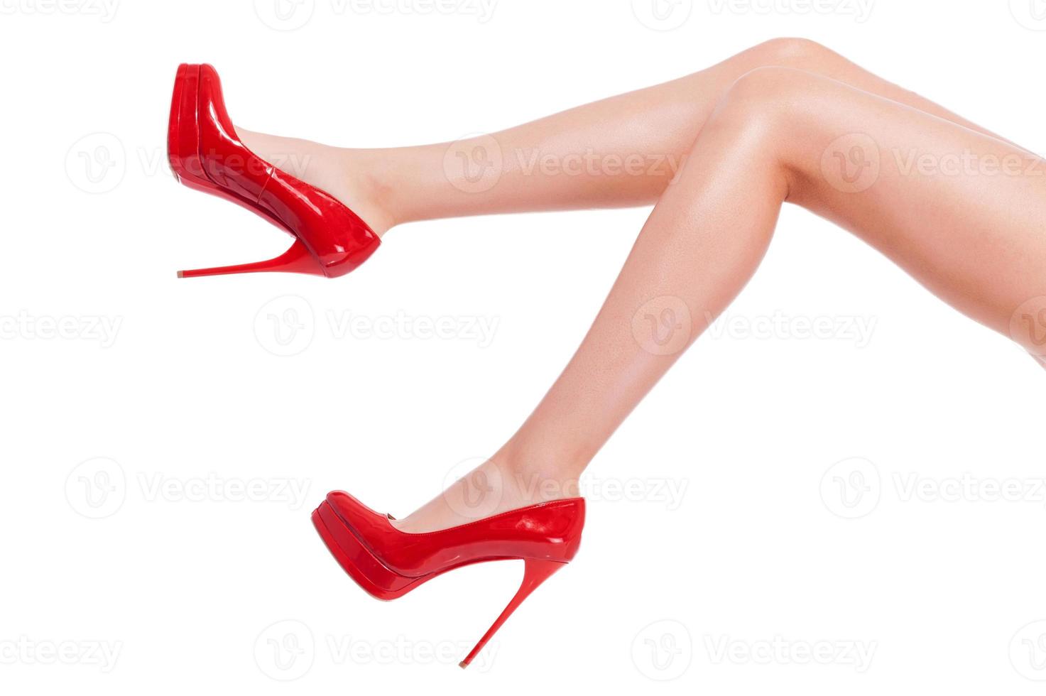 Cheeky heel. Close-up of young woman in high heeled shoes isolated on white photo