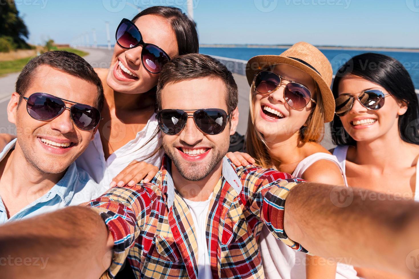 Capturing fun. Five young happy people making selfie and smiling photo