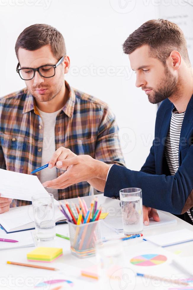 Discussing new project. Two confident business people in smart casual wear sitting together at the table and discussing something photo