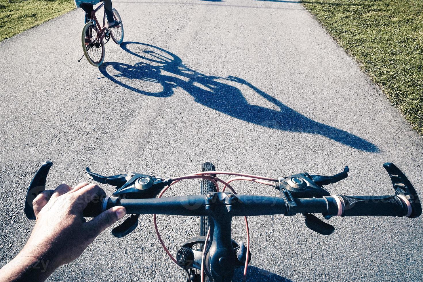 A personal point of view on a bicycle with another cyclist in front photo