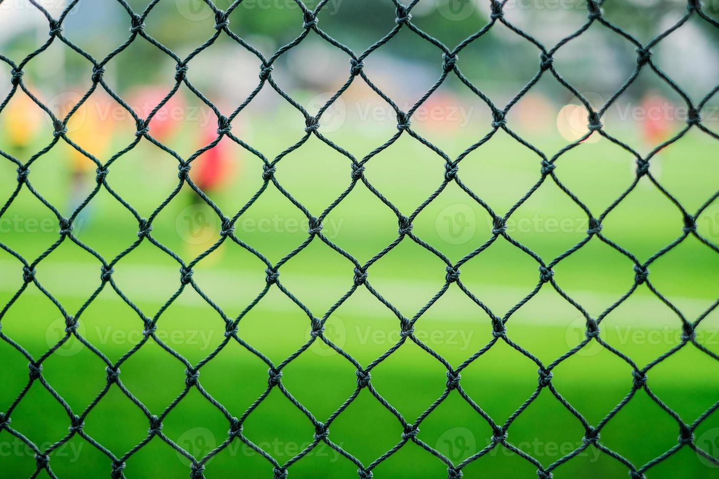 Close-up view of a soccer field perimeter fence net photo