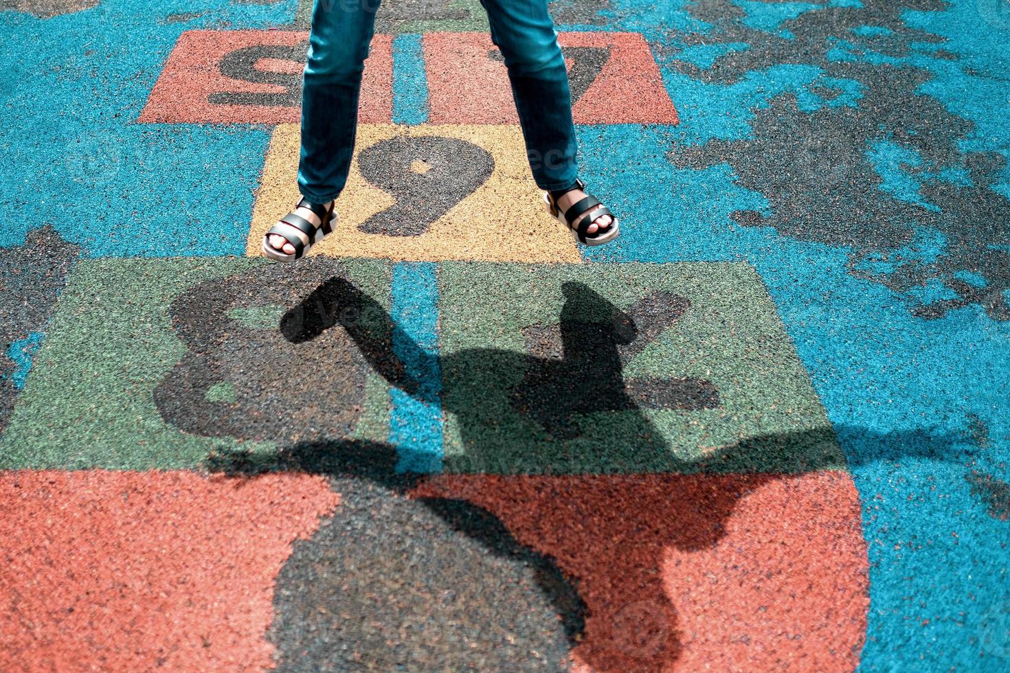 una niña saltando jugando el juego tictactoe en un día soleado foto