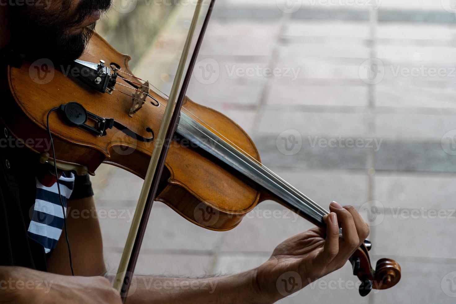 hombre tocando el violín. tema musical los dedos masculinos agarran las cuerdas y sostienen el arco foto