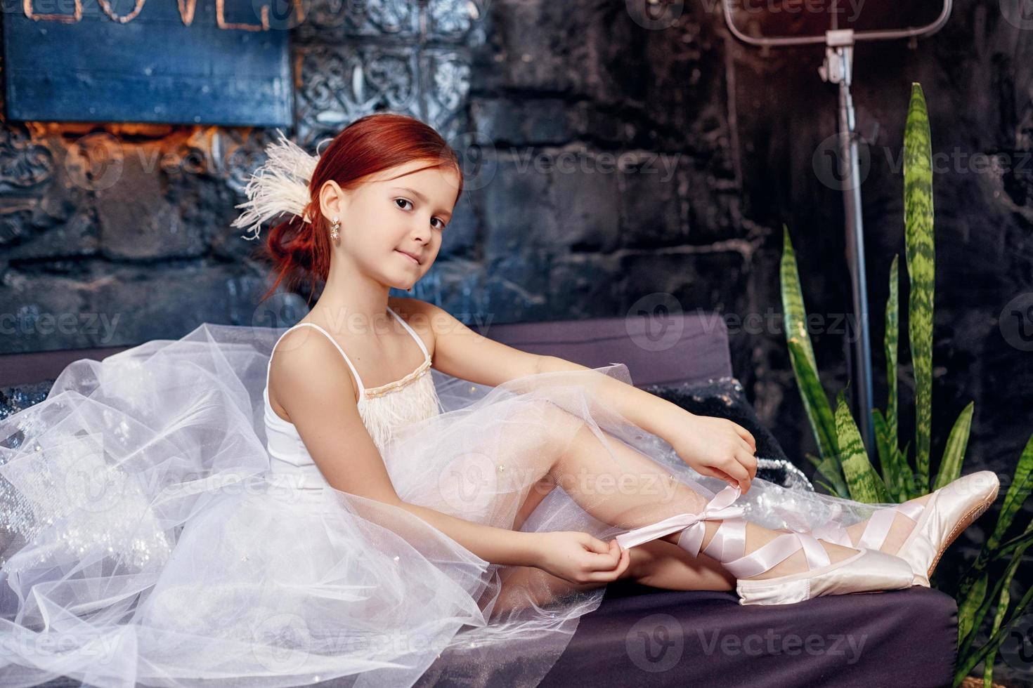 chica con un vestido blanco y zapatos, hermoso cabello rojo. joven actriz de teatro foto