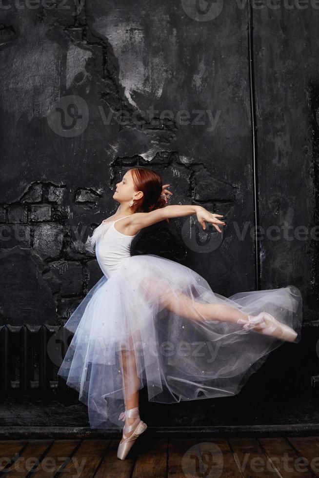 Girl in a white ball gown and shoes, beautiful red hair. Young theater actress photo