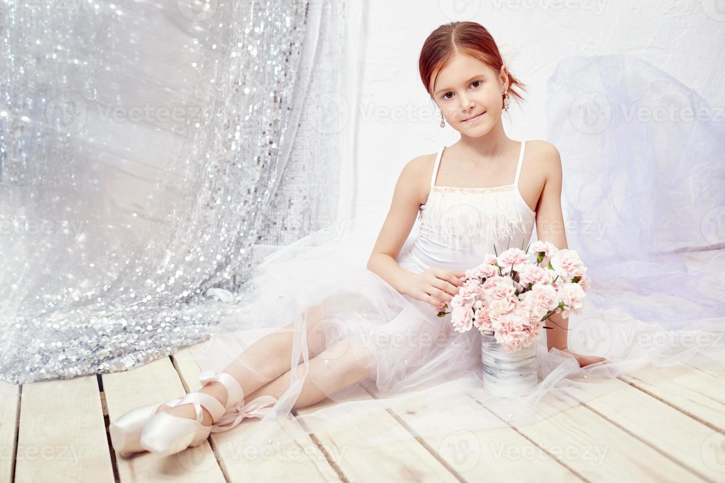 Girl in a white ball gown and shoes, beautiful red hair. Young theater actress photo