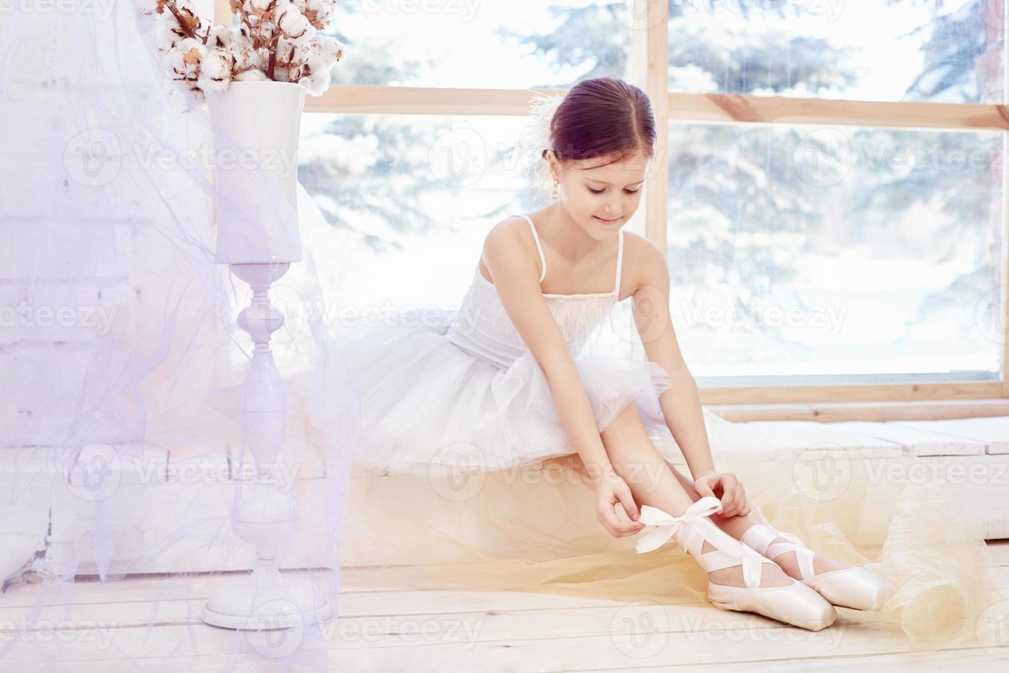 Young ballerina girl is preparing for a ballet performance. Little prima ballet photo