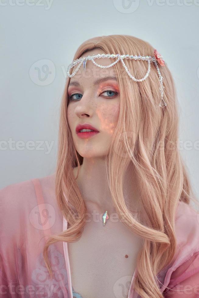 Beauty portrait of anime princess elf woman with pink hair in underwear. Fabulous magical look, beautiful pink makeup. Rim crown on the head of a woman photo