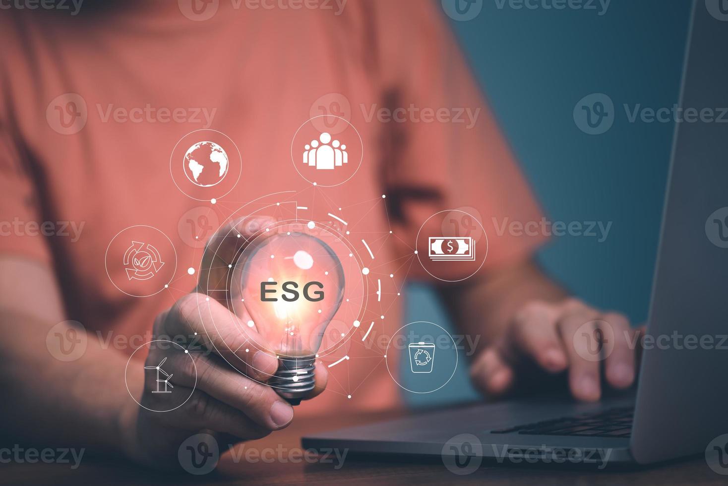 concepto esg, mano de hombre sosteniendo una bombilla con icono esg para el medio ambiente, la sociedad y la gobernanza en negocios sostenibles y éticos en la conexión de red. foto