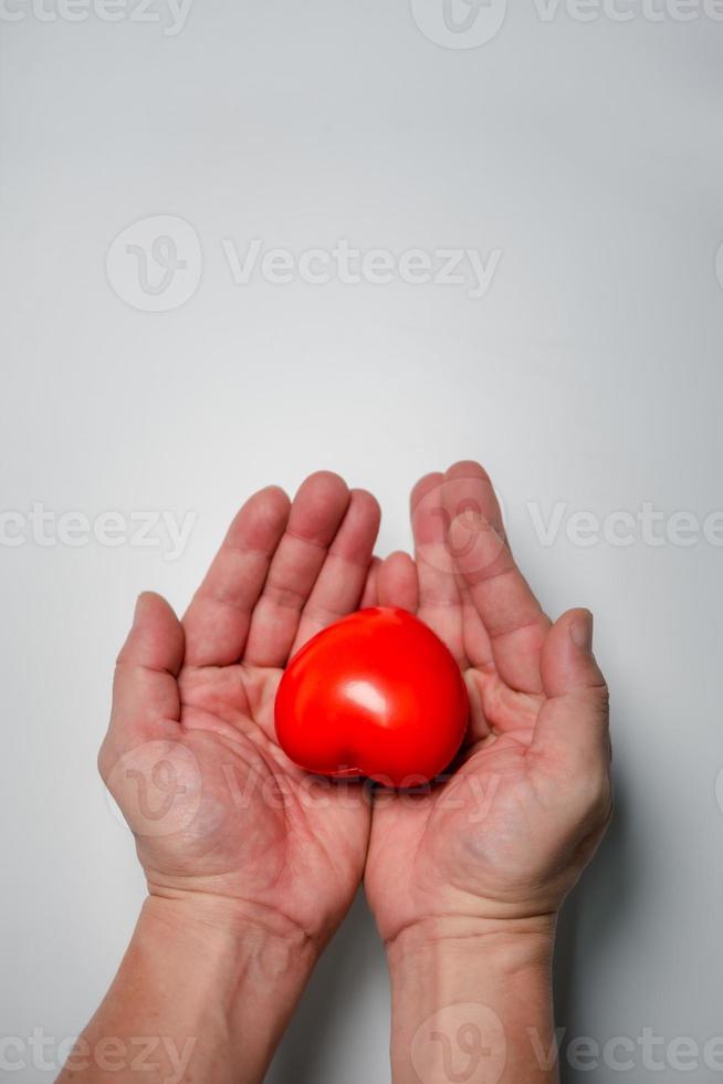 Hands holding and giving red heart for love, health care, organ donation, world heart day, world health day, mindfulness, well being, family insurance concept, copy space. photo
