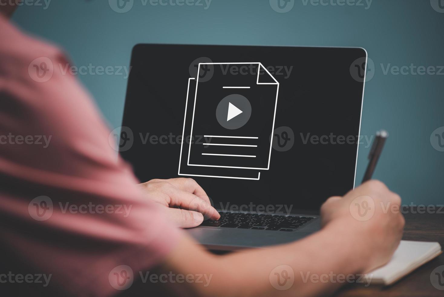 E learning concept. Casual business man studying online course via website or page on computer and writing on notebook. photo