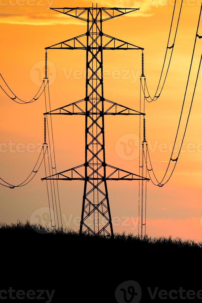 Silhouettes of high voltage poles and power lines It has a complex steel structure, it is strong and durable. photo