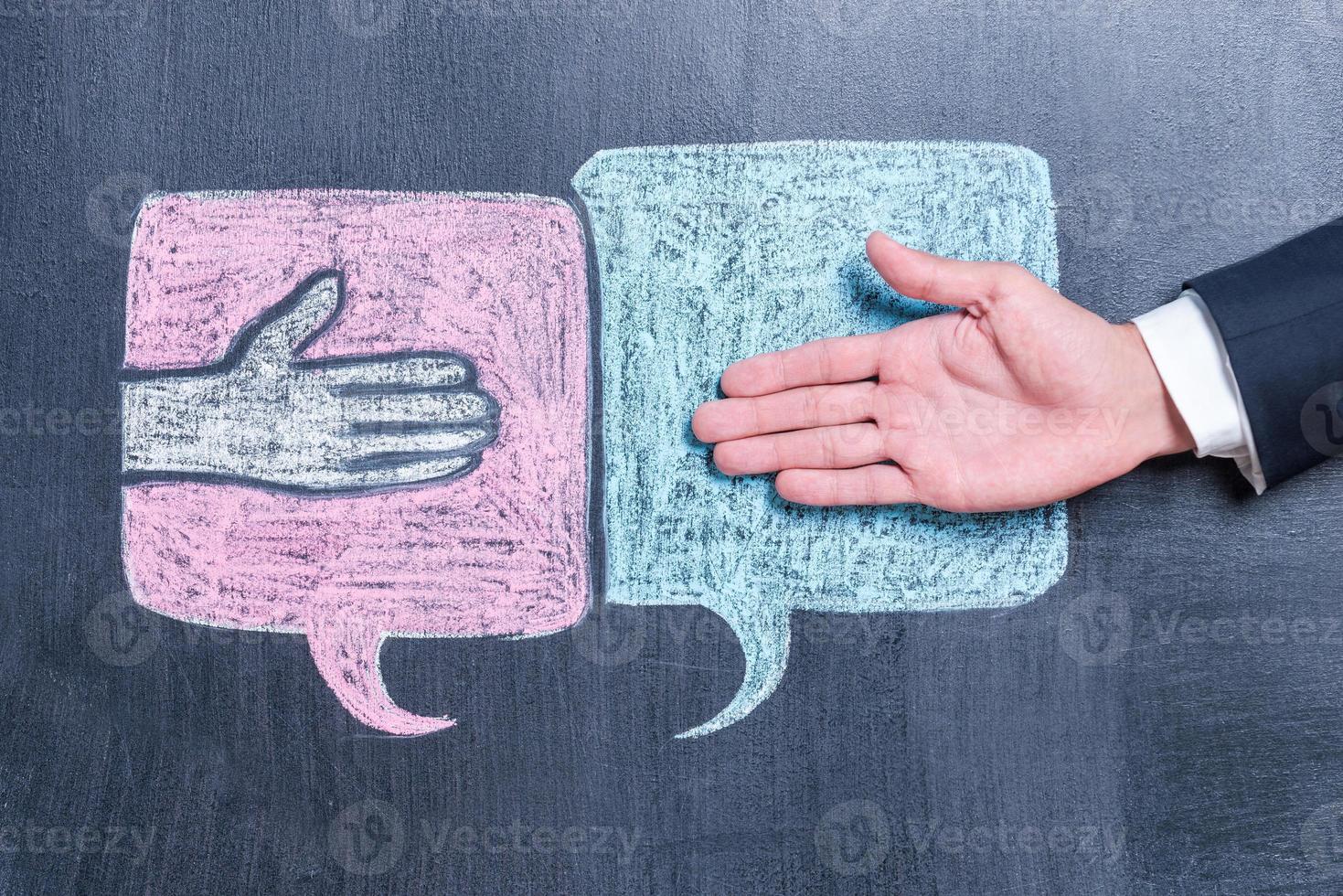 Being easy going is simple. Close-up of man stretching out hand for shaking against blackboard photo