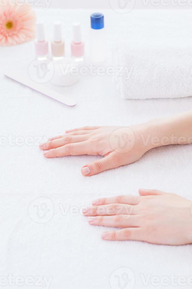 Preparing hands for manicure. Close-up of female hands on the table for manicure photo