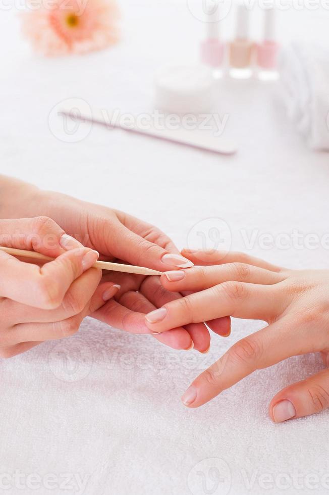 Nail pampering. Close-up of manicure master preparing customers nails for manicure photo