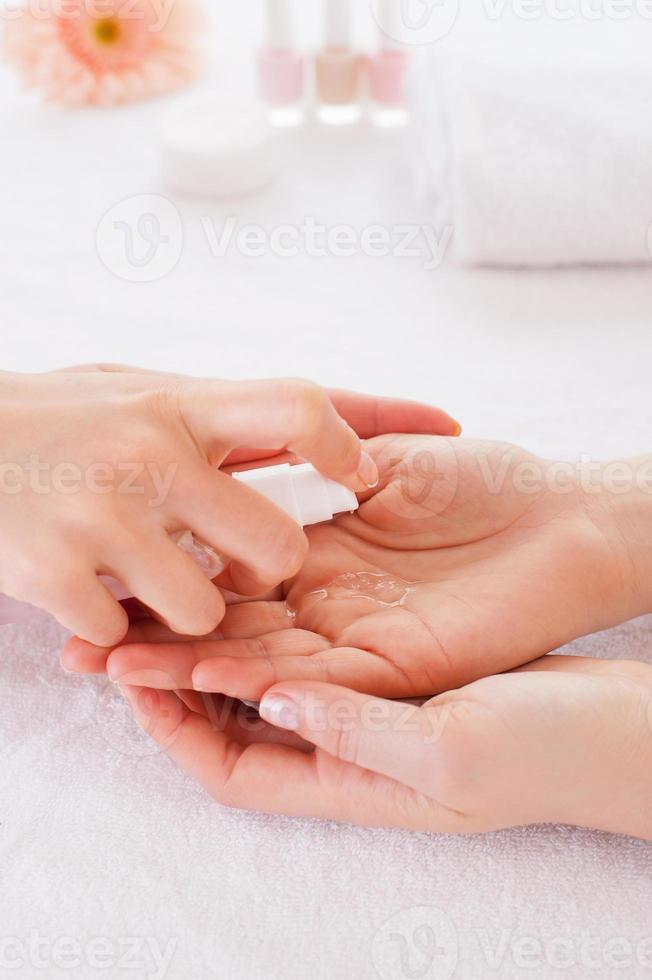 Spraying antiseptic. Close-up of manicure master spraying antiseptic on female finger photo