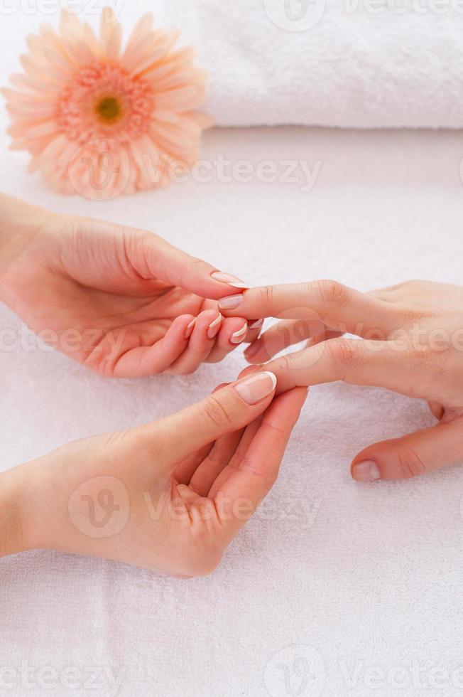 Massage for fingers. Close-up of massage therapist massaging fingers of female customer photo