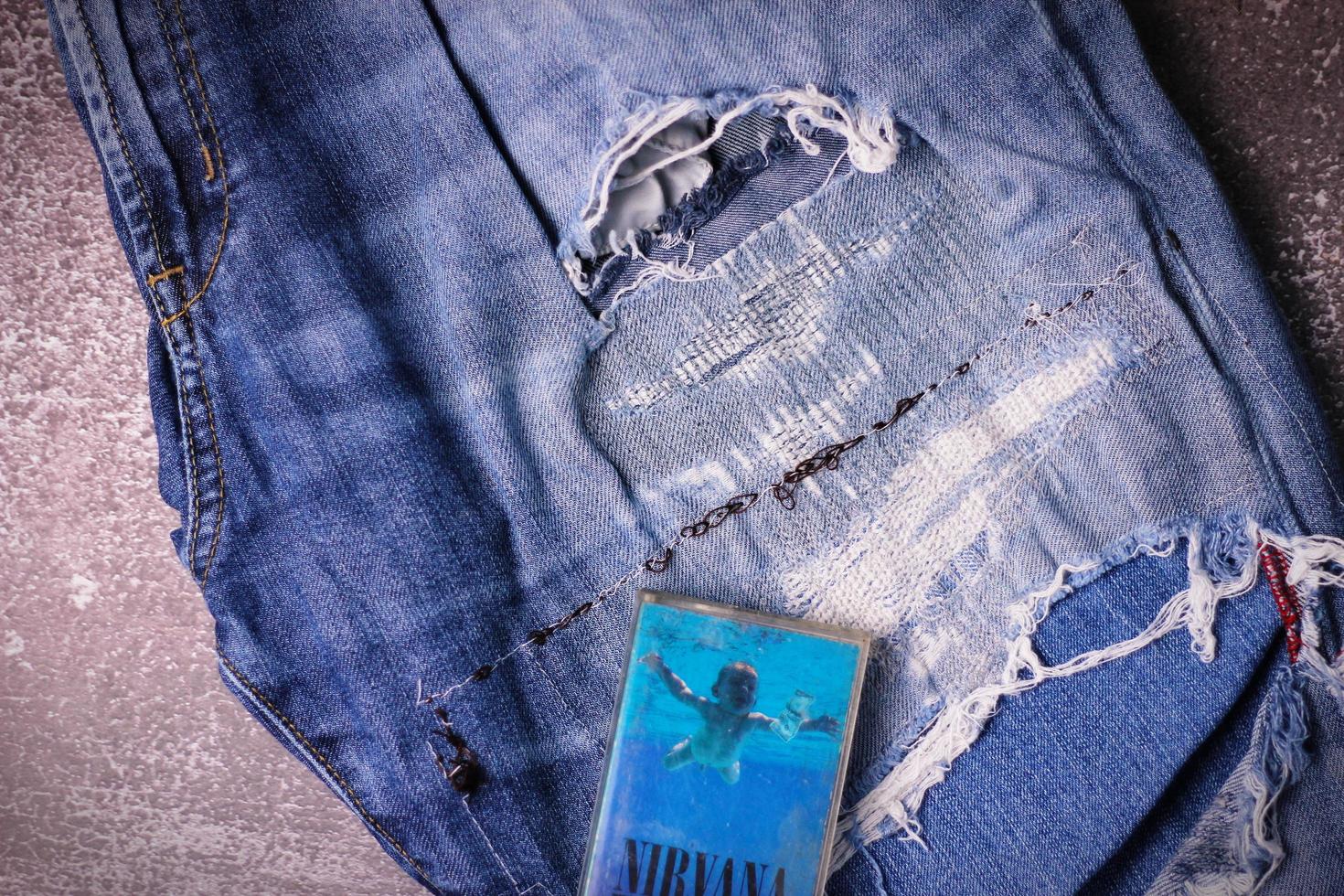 WASHINGTON USA - September 30 2022  Nirvana's cassette tape and Ripped jeans or Torn jeans. A symbol of the grunge or Seattle sound. photo