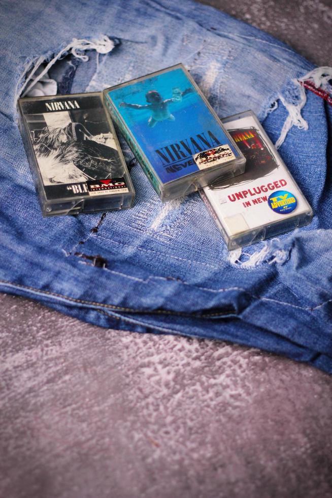 WASHINGTON USA - September 30 2022  Nirvana's cassette tape and Ripped jeans or Torn jeans. A symbol of the grunge or Seattle sound. photo