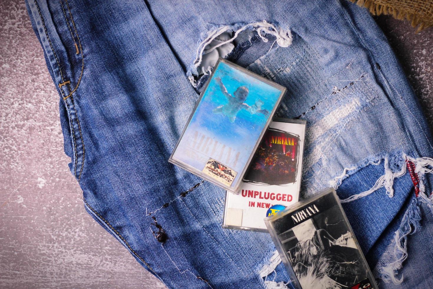 WASHINGTON USA - September 30 2022  Nirvana's cassette tape and Ripped jeans or Torn jeans. A symbol of the grunge or Seattle sound. photo