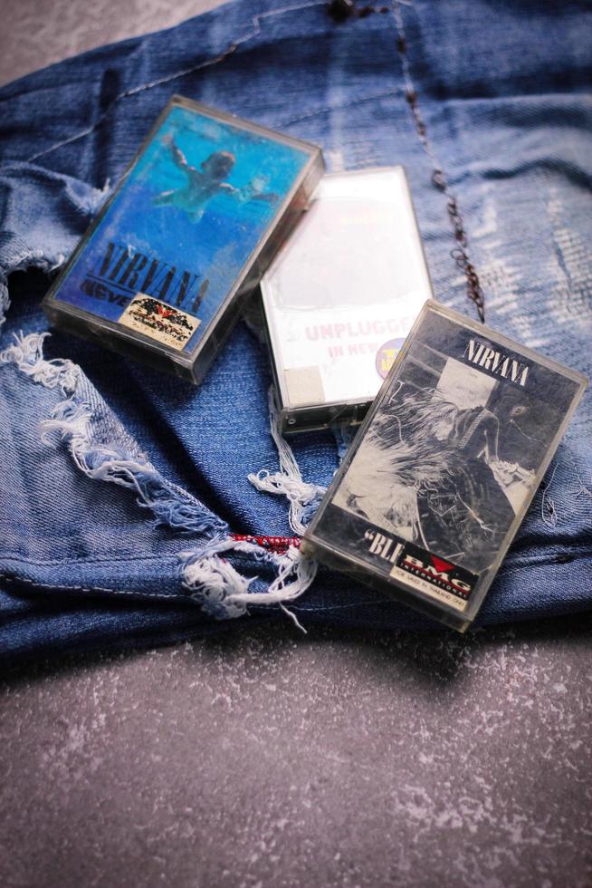 WASHINGTON USA - September 30 2022  Nirvana's cassette tape and Ripped jeans or Torn jeans. A symbol of the grunge or Seattle sound. photo