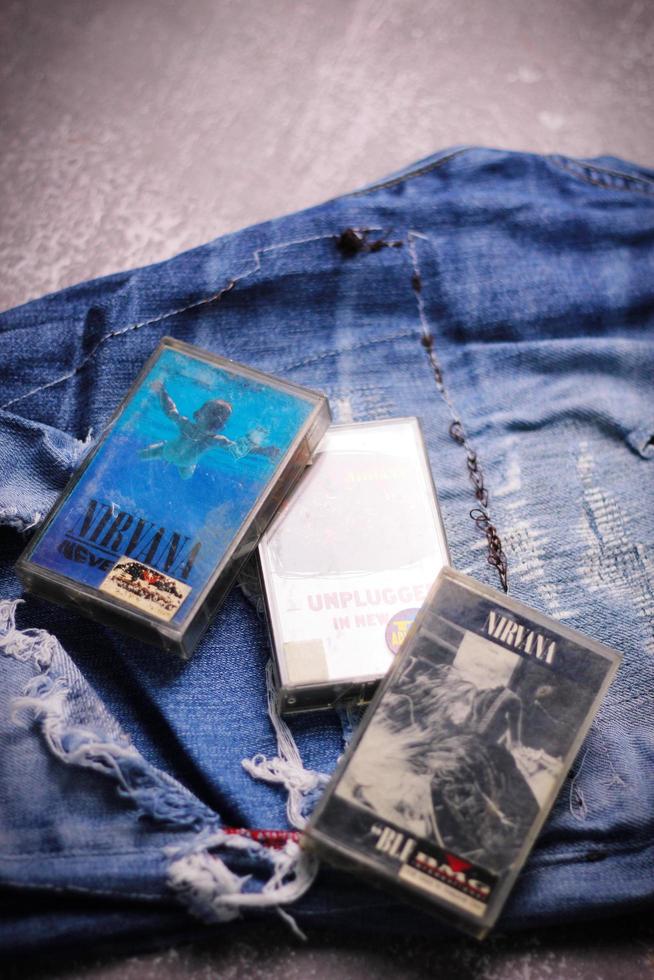 WASHINGTON USA - September 30 2022  Nirvana's cassette tape and Ripped jeans or Torn jeans. A symbol of the grunge or Seattle sound. photo