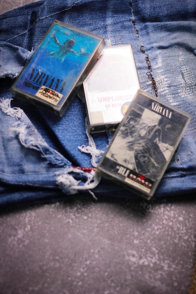 WASHINGTON USA - September 30 2022  Nirvana's cassette tape and Ripped jeans or Torn jeans. A symbol of the grunge or Seattle sound. photo