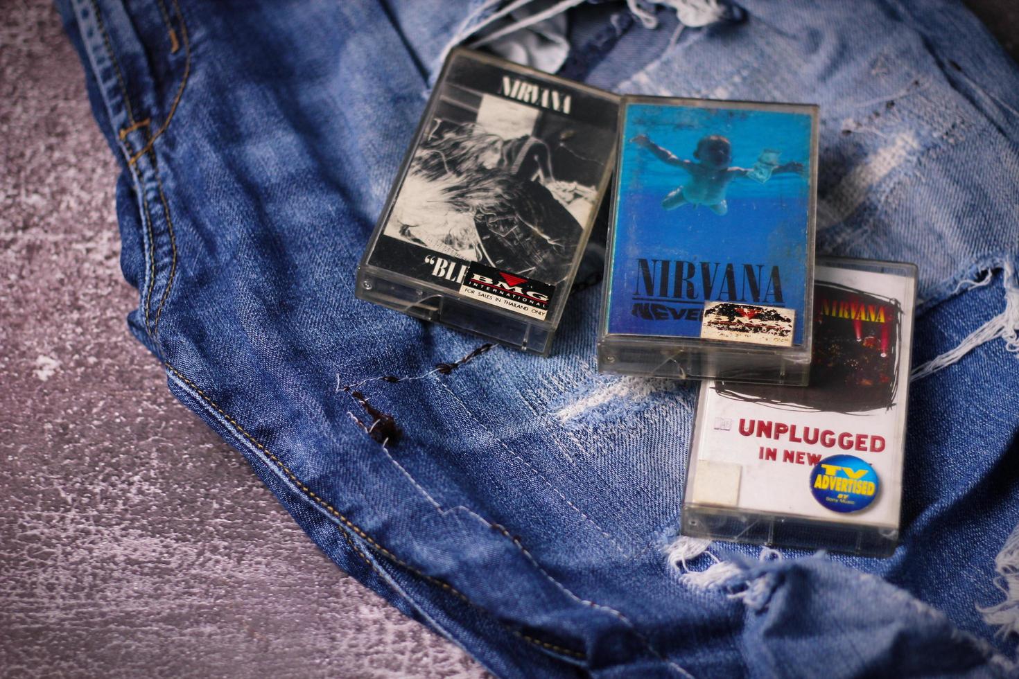 WASHINGTON USA - September 30 2022  Nirvana's cassette tape and Ripped jeans or Torn jeans. A symbol of the grunge or Seattle sound. photo