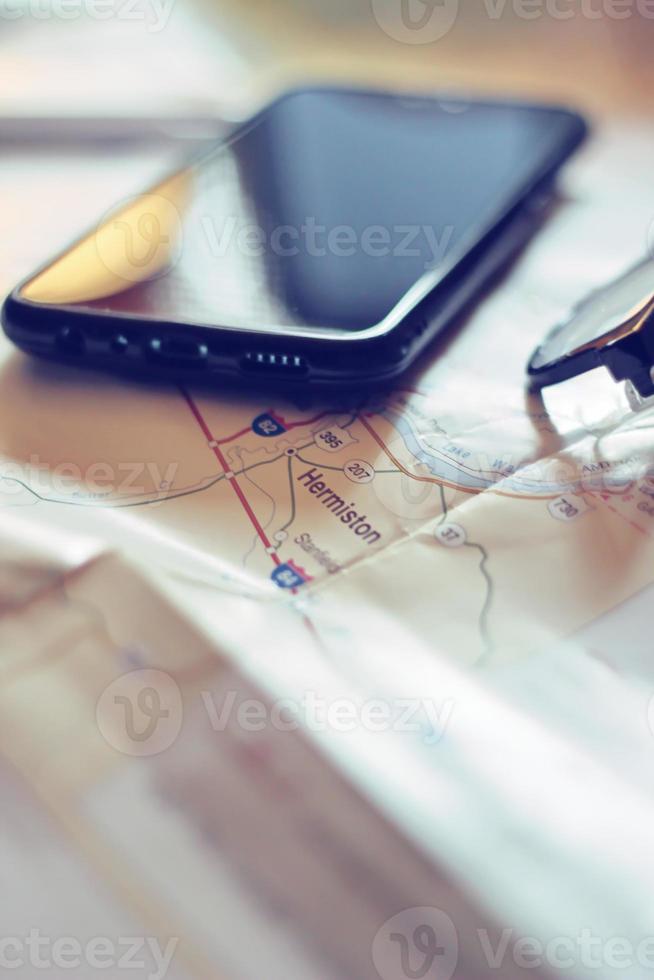 Map, map of Washington state, pen, glasses, cell phone, coffee cup on the table. photo